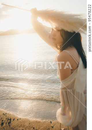 一個女人站在沙灘上的照片 95478222