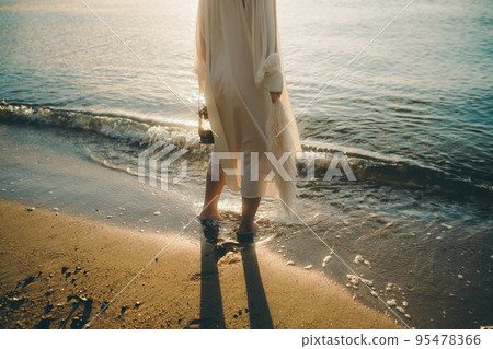 Photo of a woman standing by the beach Photo of a woman standing by the beach 95478366