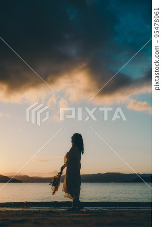 站在沙灘上的女人的剪影照片 95478961