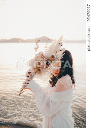 Photo of a woman standing by the beach 95479017