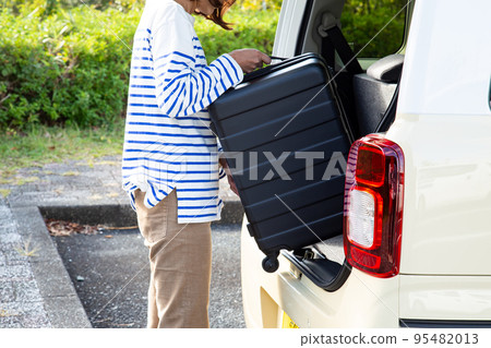 女人在車裡提著行李箱 95482013