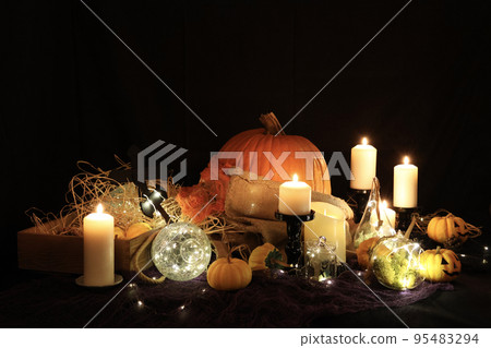 Halloween decorations, ghost pumpkins and jack-o'-lanterns lit by candlelight 95483294