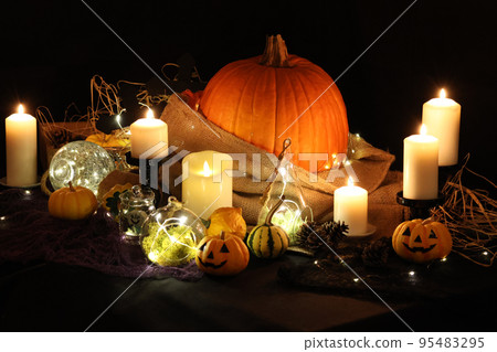 Halloween decorations, ghost pumpkins and jack-o'-lanterns lit by candlelight 95483295