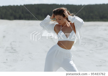 Beautiful woman standing on seashore 95483762