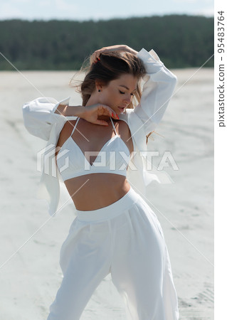 Beautiful woman standing on seashore 95483764
