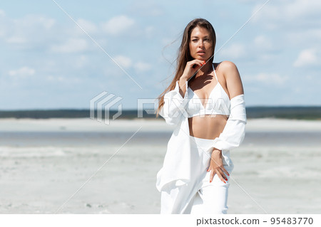 Beautiful woman standing on seashore 95483770