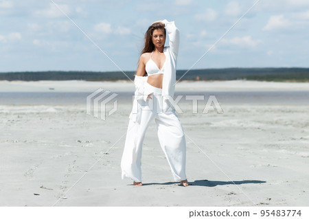 Beautiful woman standing on seashore 95483774