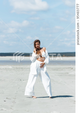 Beautiful woman standing on seashore 95483777