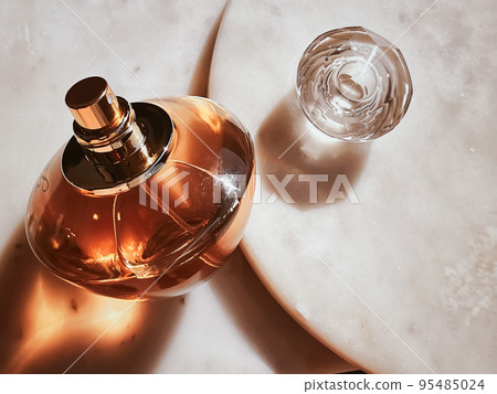 Flacon of perfume, luxury fragrance, glass bottle on marble stone background, beauty product concept Flacon of perfume, luxury fragrance, glass bottle on marble stone background, beauty product concept 95485024