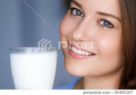 Happy young woman with glass of milk or protein milk shake, healthy cocktail drink for diet and wellness concept Happy young woman with glass of milk or protein milk shake, healthy cocktail drink for diet and wellness concept 95485167