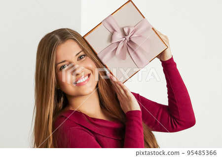 Holiday present for birthday, baby shower, wedding or luxury beauty box subscription delivery, happy woman holding a wrapped pink gift on white background Holiday present for birthday, baby shower, wedding or luxury beauty box subscription delivery, happy woman holding a wrapped pink gift on white background 95485366