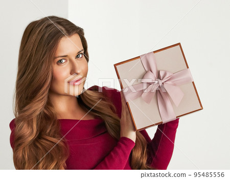 Holiday present for birthday, baby shower, wedding or luxury beauty box subscription delivery, happy woman holding a wrapped pink gift on white background 95485556