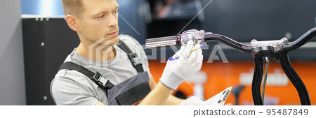 Garage service worker check wheel on motorbike, hold clipboard with info Garage service worker check wheel on motorbike, hold clipboard with info 95487849