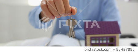 Male worker in suit give key to unlock new miniature house, buy new accommodation Male worker in suit give key to unlock new miniature house, buy new accommodation 95487895