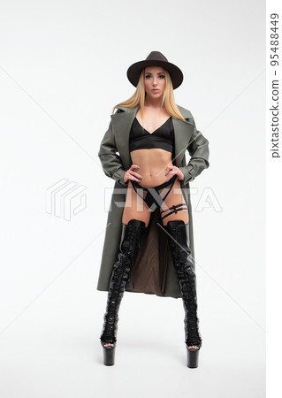 Sensual young lady in lingerie and coat looking at camera in studio 95488449