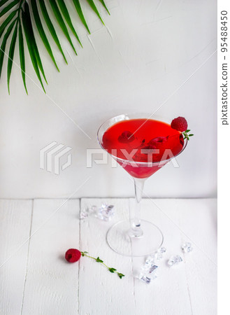 Red alcohol cocktail with raspberries and thyme on the white wood table. Red alcohol cocktail with raspberries and thyme on the white wood table. 95488450