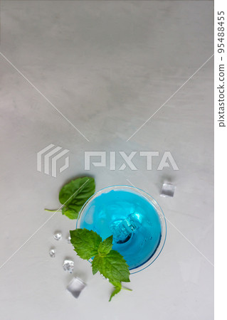 Top view of blue cocktail in martini glass with ice cubes and mint 95488455