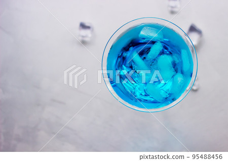 Top view of blue cocktail in martini glass with ice cubes 95488456