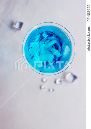 Top view of blue cocktail in martini glass with ice cubes 95488461