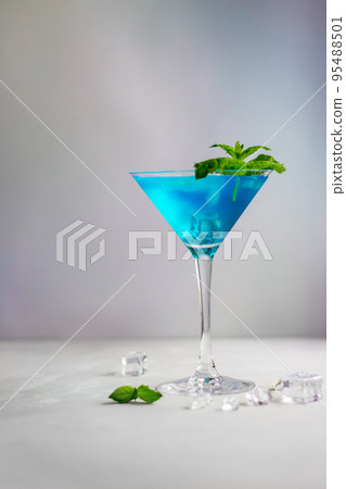 Blue cocktail in martini glass with ice cubes and mint 95488501