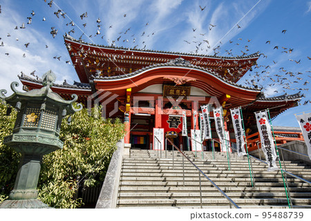 Nagoya City Main Hall (Daihiden) of Osu Kannon and a flock of flying pigeons 95488739
