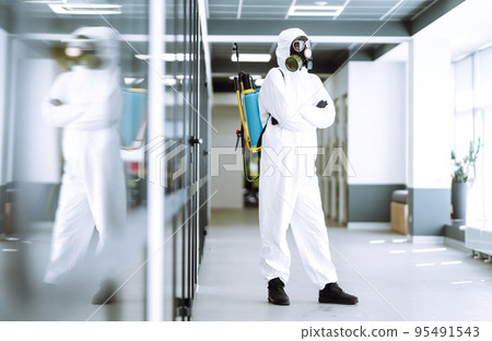 Man in protective hazmat suit in an empty office. Concepts to preventing the spread of coronavirus. 95491543