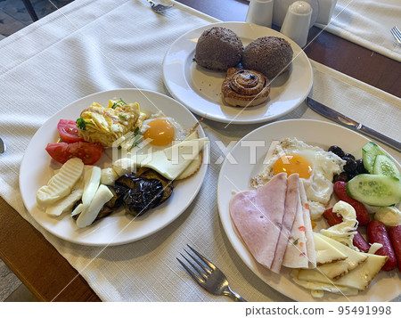 Lunch. Plates of eggs, ham, cheese and vegetables on table. Studio Photo Lunch. Plates of eggs, ham, cheese and vegetables on table. Studio Photo 95491998