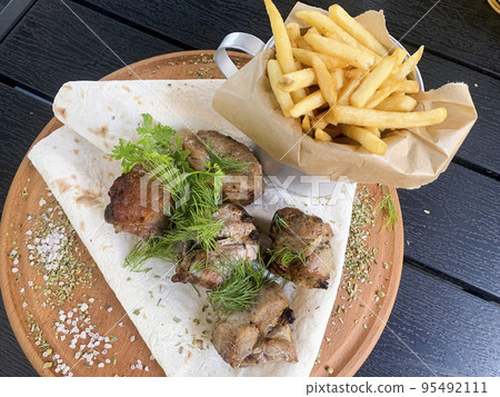 Street fast food, French fries, pita bread and pieces of grilled meat. Studio Photo 95492111