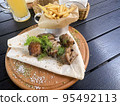 Street fast food, French fries, pita bread and pieces of grilled meat. Studio Photo 95492113