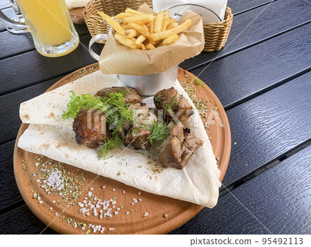 Street fast food, French fries, pita bread and pieces of grilled meat. Studio Photo Street fast food, French fries, pita bread and pieces of grilled meat. Studio Photo 95492113