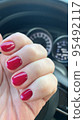 Short nails with colored nail polish on woman's hand. Stuio Photo 95492117