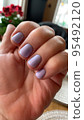 Short nails with colored nail polish on woman's hand. Stuio Photo 95492120