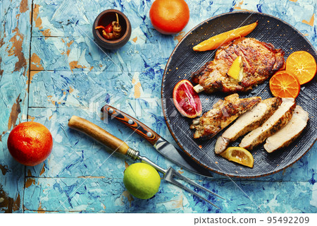 Meat roasted in orange sauce. 95492209
