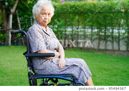 Asian elderly woman disability patient sitting on wheelchair in park, medical concept. Asian elderly woman disability patient sitting on wheelchair in park, medical concept. 95494367