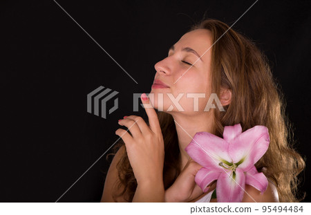 Beauty face of the young beautiful woman with flower. Female touching skin. 95494484