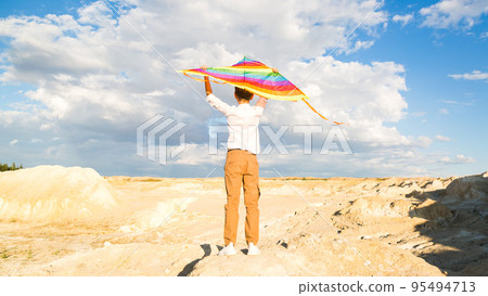 A boy of 8-9 years old happily launches a kite into the sky A boy of 8-9 years old happily launches a kite into the sky 95494713