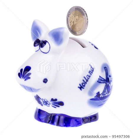 Piggy bank in a shape of a cow with blue ornament, coin falling 95497306