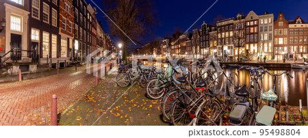 Beautiful old houses on the city waterfront of Amsterdam at sunset. 95498804