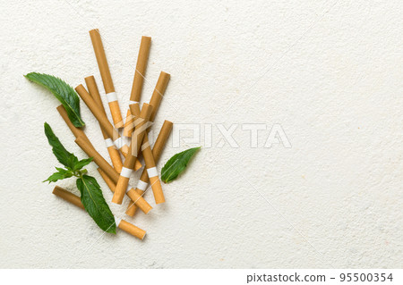 Menthol cigarettes and fresh mint leaves on colored background, Many cigarettes stacked together top view flat lay 95500354