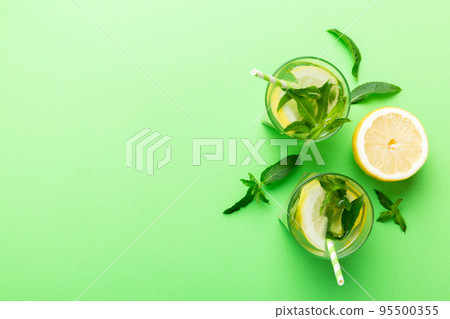Caipirinha, Mojito cocktail, vodka or soda drink with lime, mint and straw on table background. Refreshing beverage with mint and lime in glass top view flat lay 95500355