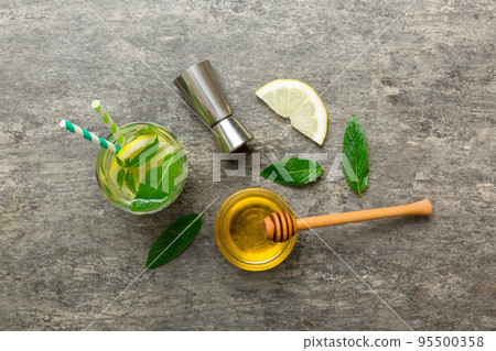 Caipirinha, Mojito cocktail, vodka or soda drink with lime, mint and straw on table background. Refreshing beverage with mint and lime in glass top view flat lay 95500358