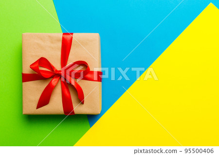 holiday brown paper present tied red ribbon bow top view with copy space. Flat lay holiday background. Birthday or christmas present. Christmas gift box concept with copy space 95500406
