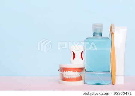 Mouthwash and other oral hygiene products on colored table top view with copy space. Flat lay. Dental hygiene. Oral care kit. Dentist concept Mouthwash and other oral hygiene products on colored table top view with copy space. Flat lay. Dental hygiene. Oral care kit. Dentist concept 95500471