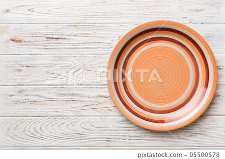 Top view of empty orange plate on wooden background. Empty space for your design Top view of empty orange plate on wooden background. Empty space for your design 95500578