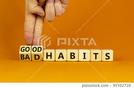 Good or bad habits symbol. Businessman turns wooden cubes and changes words 'bad habits' to 'good habits'. Beautiful orange table, orange background. Business, bad or good habits concept. Copy space. Good or bad habits symbol. Businessman turns wooden cubes and changes words 'bad habits' to 'good habits'. Beautiful orange table, orange background. Business, bad or good habits concept. Copy space. 95502720