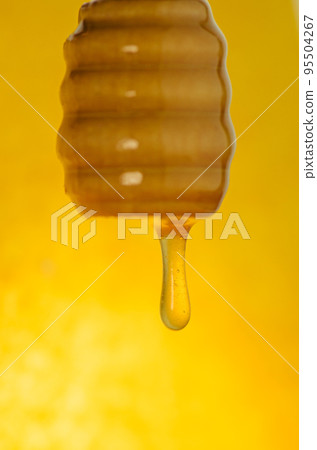 Honey dipping from the wooden honey spoon Honey dipping from the wooden honey spoon 95504267
