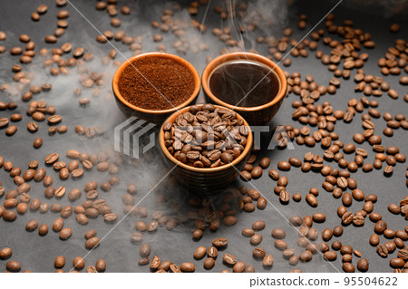 Set of three cups of coffee beans, ground and drink on a black background. Set of three cups of coffee beans, ground and drink on a black background. 95504622