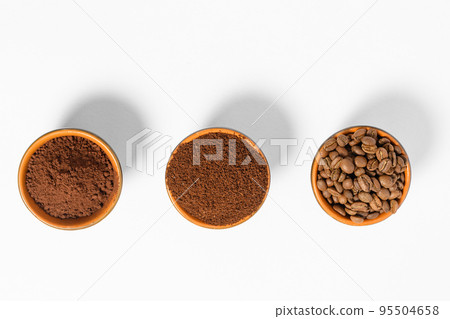 Three cups of coffee beans, ground coffee and cocoa for comparison. Three cups of coffee beans, ground coffee and cocoa for comparison. 95504658