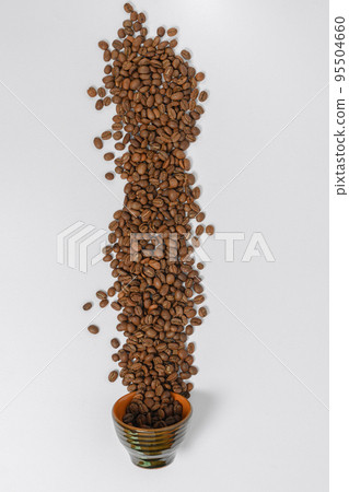 Path of coffee beans spilled from a mug, coffee on an isolated white background. 95504660
