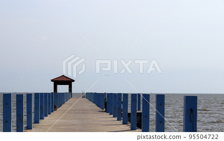 Perspective view of Pier at the sea, jetty and sea in sun light. Perspective view of Pier at the sea, jetty and sea in sun light. 95504722